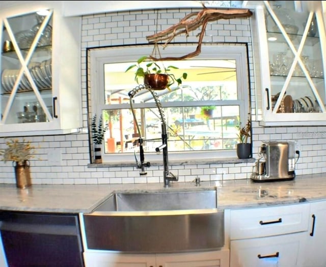 225 Temple Cir, Eustis, FL 32726 - kitchen with backsplash, white cabinetry, glass insert cabinets, and light stone counters