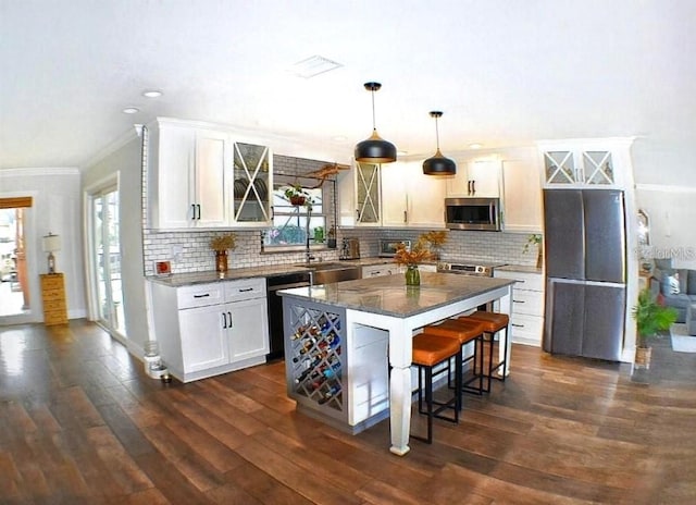 225 Temple Cir, Eustis, FL 32726 - kitchen with stainless steel microwave, a sink, black dishwasher, ornamental molding, and a breakfast bar area