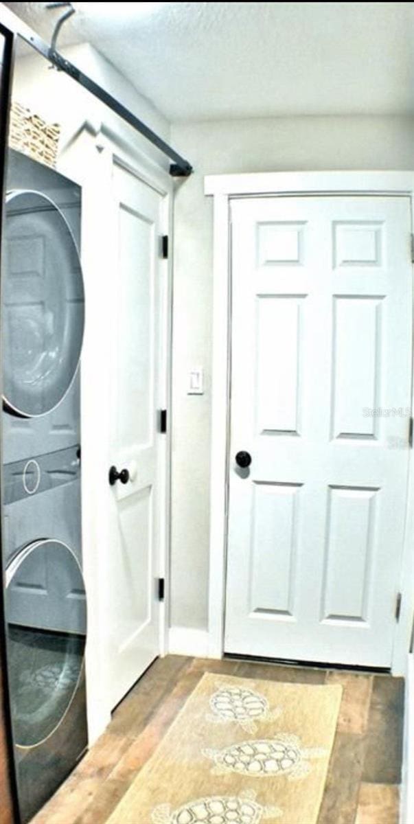 225 Temple Cir, Eustis, FL 32726 - laundry room featuring stacked washer and clothes dryer, light wood-style flooring, and baseboards