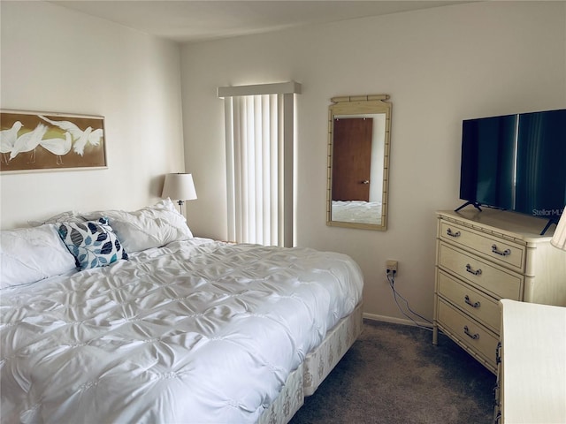 bedroom featuring baseboards and dark colored carpet