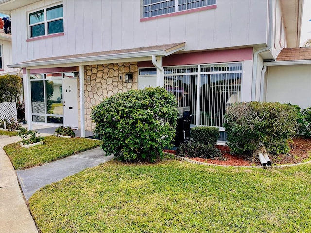 view of exterior entry with a lawn