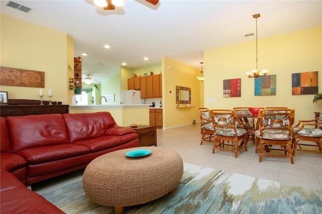 living room featuring light tile patterned floors and ceiling fan with notable chandelier