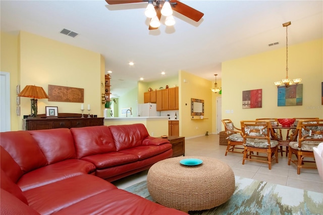 living room featuring light tile patterned flooring and ceiling fan with notable chandelier