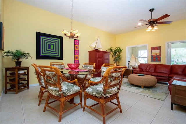 tiled dining space with ceiling fan with notable chandelier