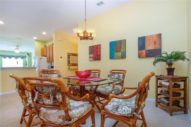 dining space with ceiling fan with notable chandelier and light tile patterned floors