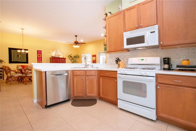 kitchen featuring decorative light fixtures, kitchen peninsula, sink, white appliances, and ceiling fan with notable chandelier