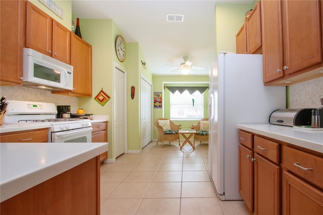 kitchen featuring ceiling fan, light tile patterned floors, backsplash, and white appliances