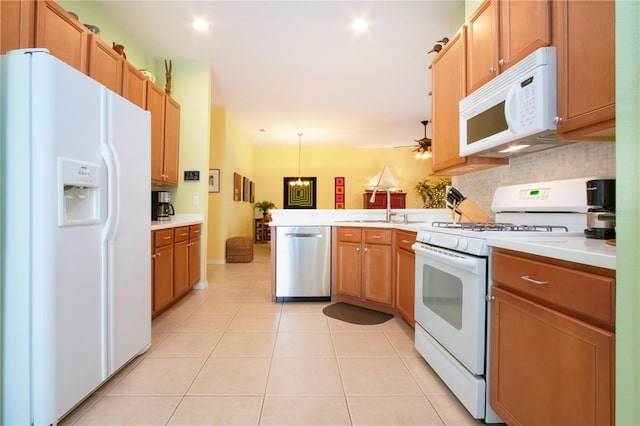 kitchen featuring decorative light fixtures, kitchen peninsula, sink, white appliances, and light tile patterned floors