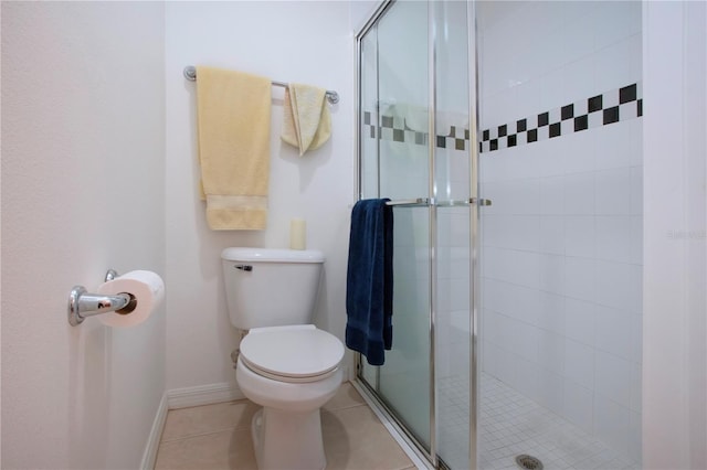 bathroom featuring toilet, tile patterned flooring, and a shower with door