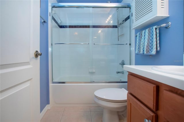 full bathroom featuring toilet, bath / shower combo with glass door, tile patterned floors, and vanity