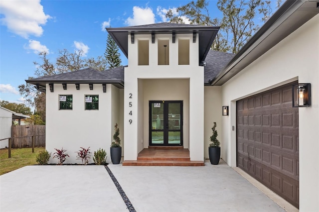 doorway to property with a garage and french doors