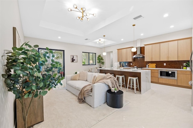 living room with a raised ceiling and a chandelier