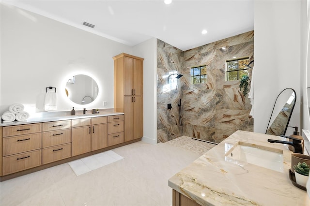 bathroom featuring vanity, tile patterned flooring, and tiled shower