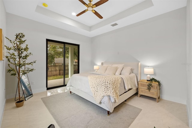 bedroom with a raised ceiling, access to outside, and ceiling fan