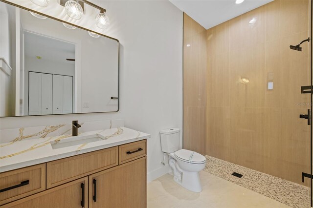 bathroom with tile patterned floors, walk in shower, vanity, and toilet