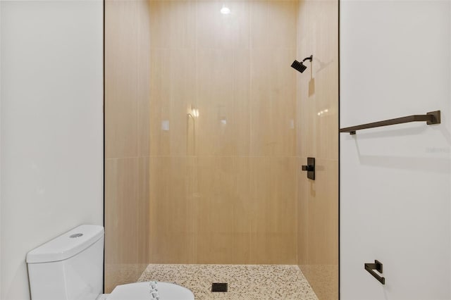 bathroom featuring toilet and tiled shower