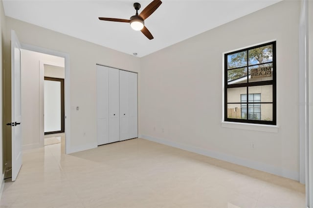 unfurnished bedroom with ceiling fan and a closet