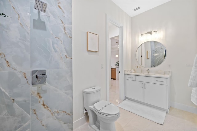 bathroom featuring toilet, vanity, a shower, and tile patterned floors