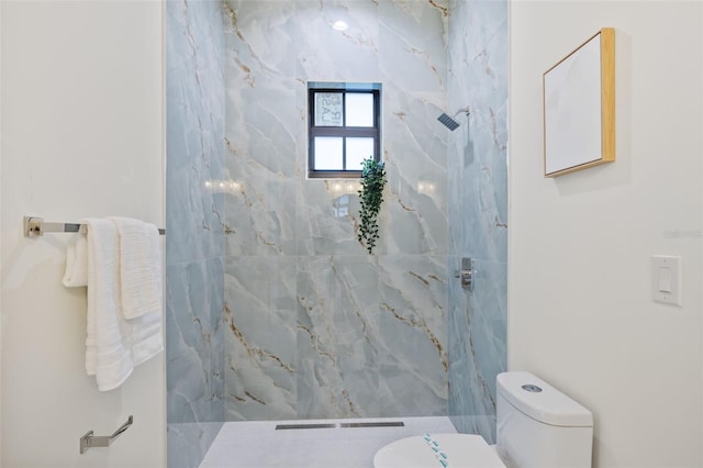 bathroom featuring toilet and a tile shower