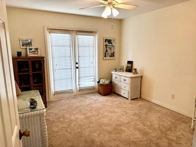 sitting room with ceiling fan and light colored carpet