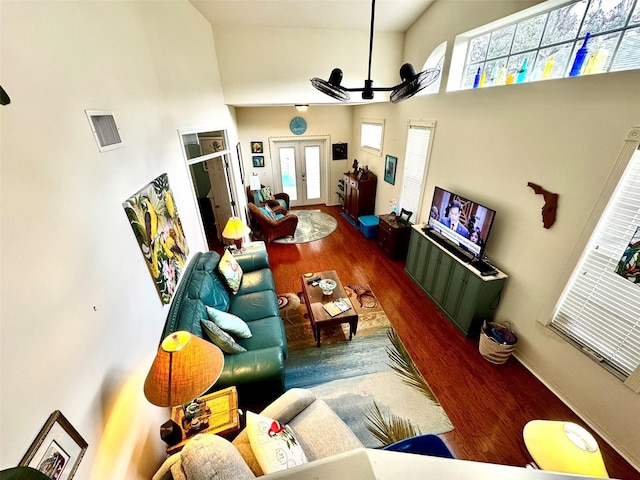 living room featuring a high ceiling, hardwood / wood-style floors, ceiling fan, and french doors