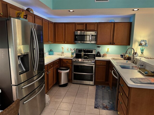 kitchen with light tile patterned flooring, appliances with stainless steel finishes, and sink