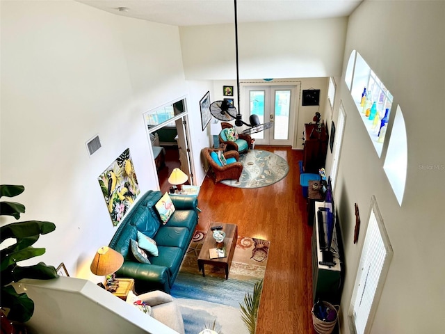 living room featuring hardwood / wood-style floors, french doors, and a high ceiling