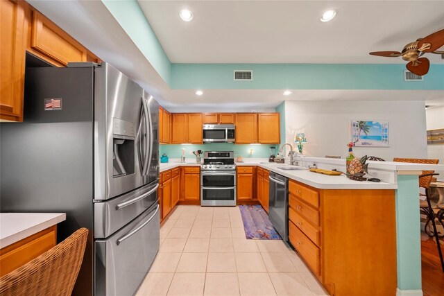 458 Grant St, Dunedin, FL 34698 - kitchen featuring appliances with stainless steel finishes, a peninsula, light tile patterned flooring, recessed lighting, and light countertops