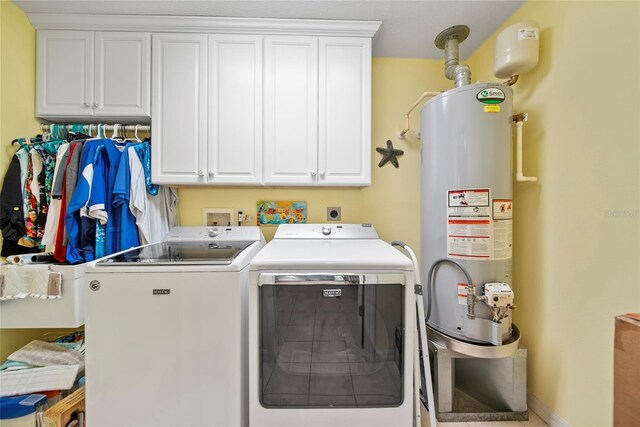 458 Grant St, Dunedin, FL 34698 - laundry area with water heater, washing machine and clothes dryer, and cabinet space