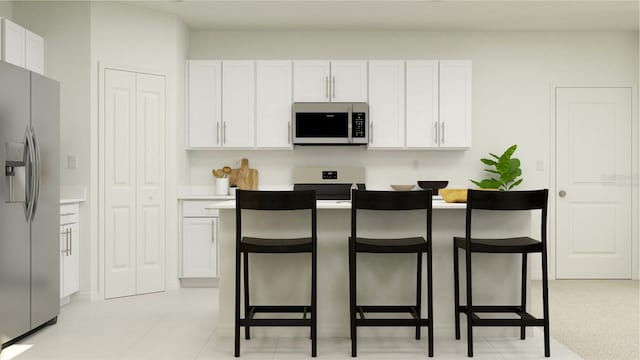 kitchen with a kitchen breakfast bar, white cabinetry, light tile patterned floors, and stainless steel appliances