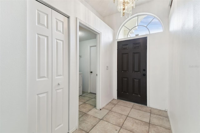 tiled entrance foyer with a notable chandelier