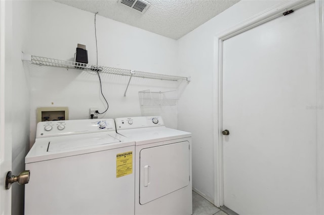 laundry area with a textured ceiling and washer and clothes dryer