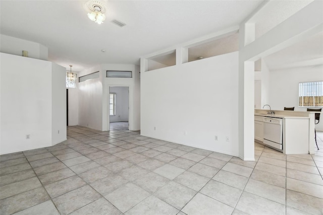 spare room with sink and a notable chandelier