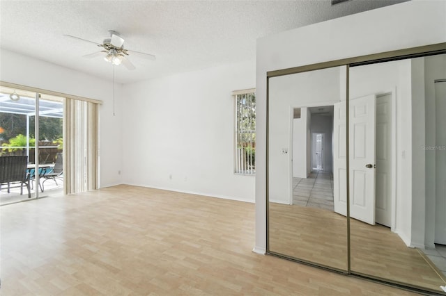 interior space with ceiling fan, a textured ceiling, a closet, and access to outside