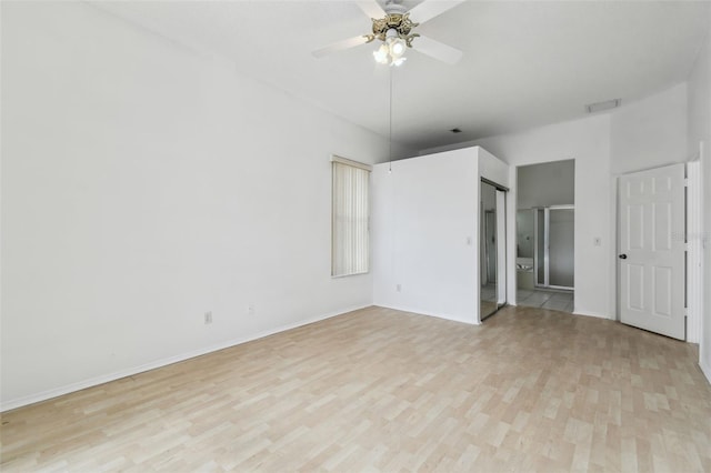 unfurnished bedroom with ceiling fan, ensuite bathroom, and light hardwood / wood-style flooring