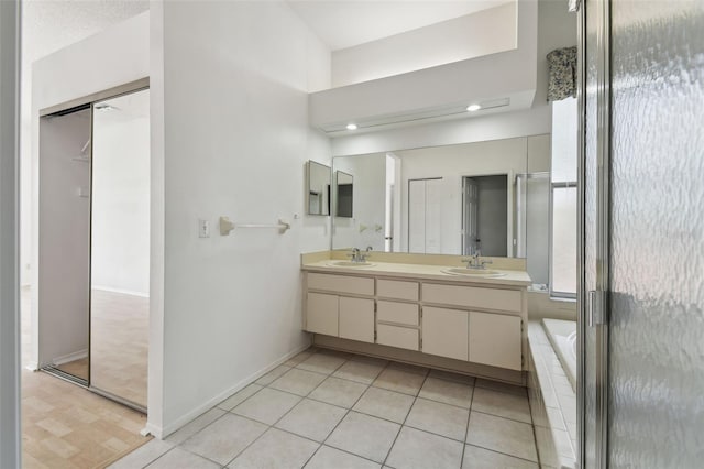 bathroom featuring tile patterned floors, tiled tub, and vanity