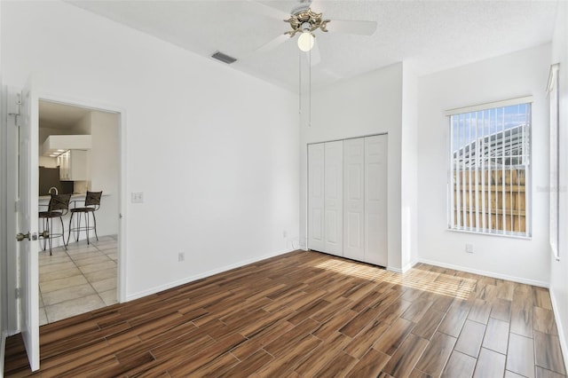 unfurnished bedroom featuring ceiling fan, a closet, and a textured ceiling