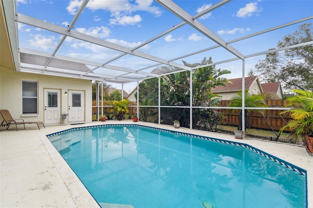 view of swimming pool with a patio and glass enclosure