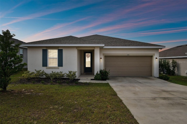 view of front facade with a yard and a garage