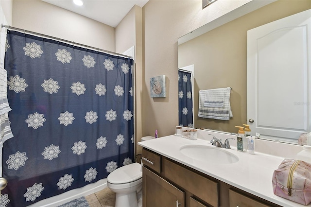 bathroom with toilet, vanity, and tile patterned flooring