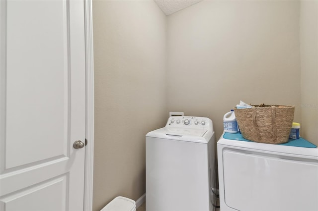 laundry room with washer and dryer and a textured ceiling