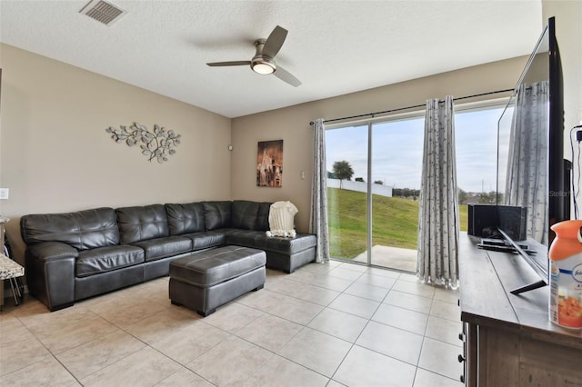 tiled living room featuring a textured ceiling and ceiling fan