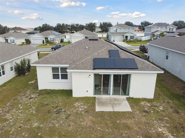 back of house with a lawn and solar panels