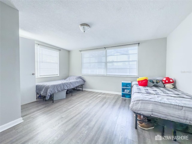 bedroom featuring hardwood / wood-style flooring and a textured ceiling