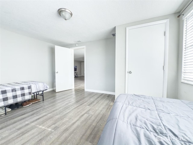 bedroom with a textured ceiling and light hardwood / wood-style flooring