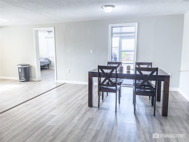 dining area with a textured ceiling and hardwood / wood-style floors