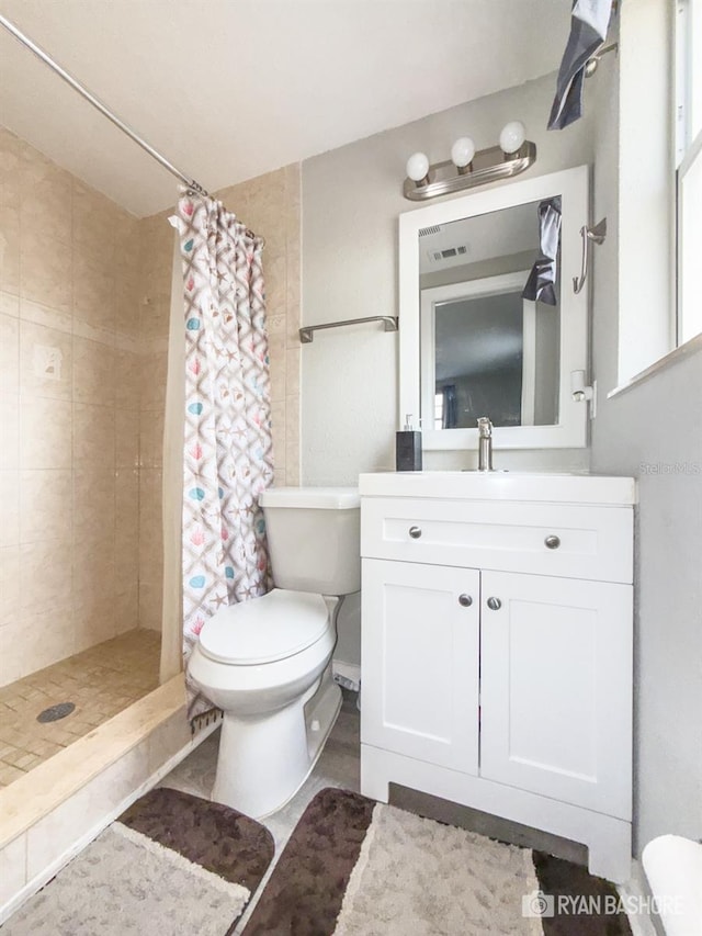 bathroom featuring toilet, vanity, and a shower with shower curtain