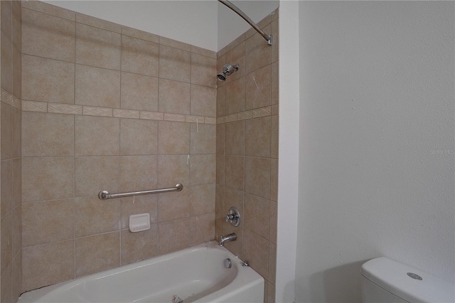 bathroom with toilet and tiled shower / bath combo