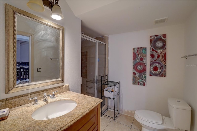 bathroom featuring toilet, tile patterned flooring, a shower with shower door, and vanity