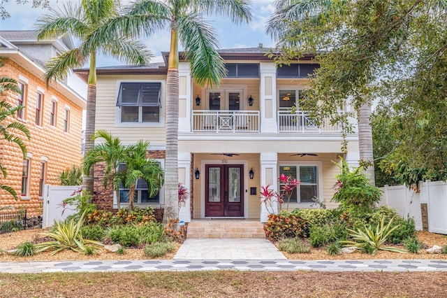 view of front facade featuring ceiling fan, french doors, and a balcony